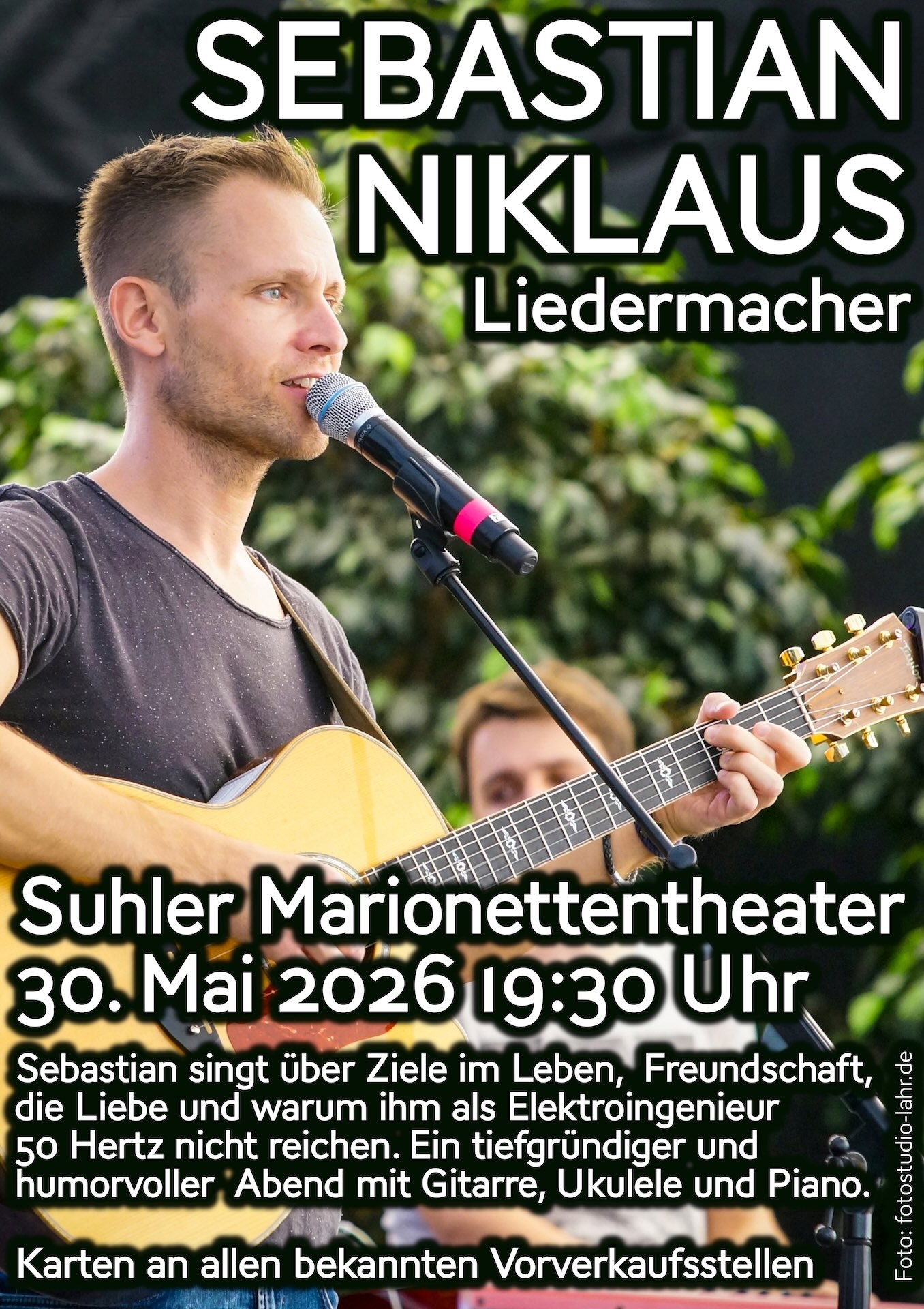 Sebastian Niklaus live auf der Bühne steht am Mikrofonstativ und spielt Akustikgitarre. Plakat als Ankündigung des Konzerts im Suhler Marionettentheater am 30. Mai 2026 19:30 Uhr
